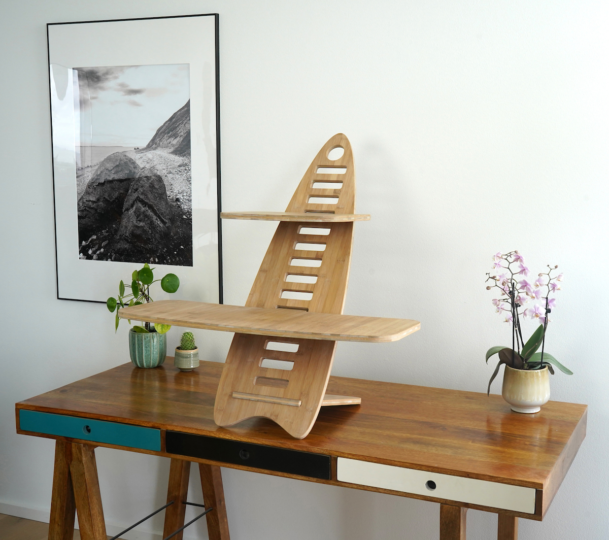 Gaia Craft Hæve sænkebord i bambus 'Naturlig'. Gaia Craft Hæve sænkebordet står på et dekoreret skrivebord