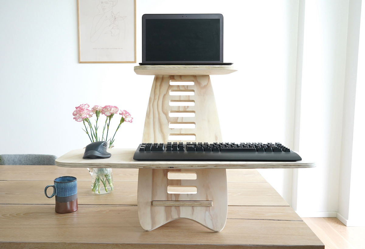 Gaia Craft hæve sænkebord Fyr, som står på et dekoreret skrivebord, med en computer, et tastatur og en mus placeret på hæve sænkebordet